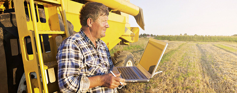 Farmer using his laptop in a field