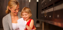 Mother with her kid collection mail from parcel lockers