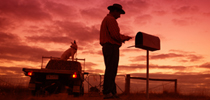 Farmer getting his mail from an old country mailbox