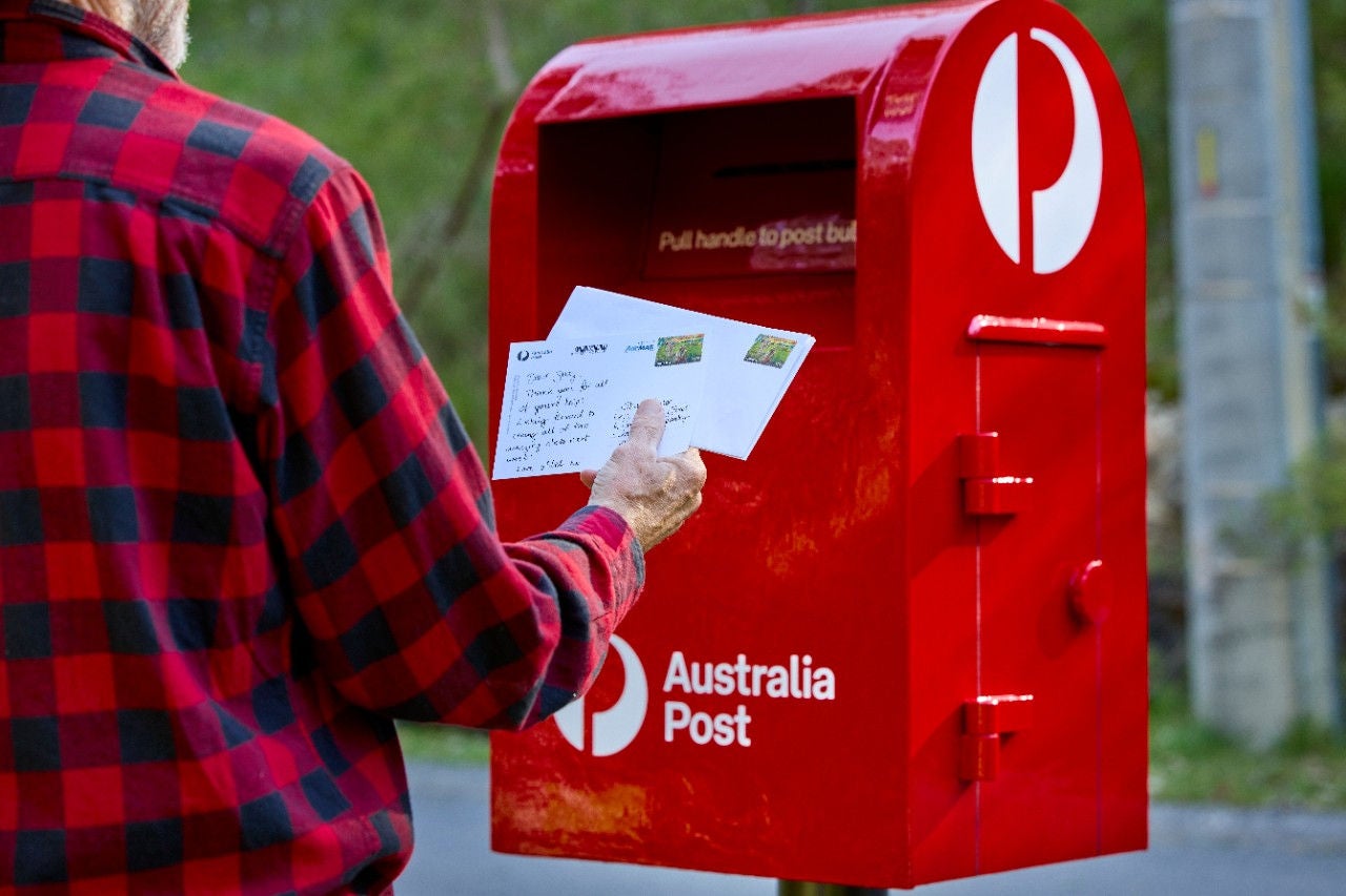 Photo of a man posting into a posting box