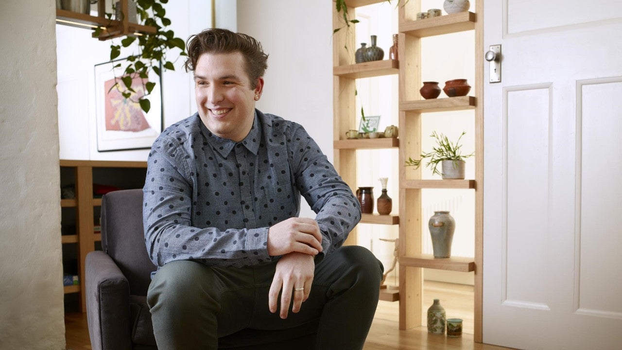  photo young man sitting on chair in living room smiling