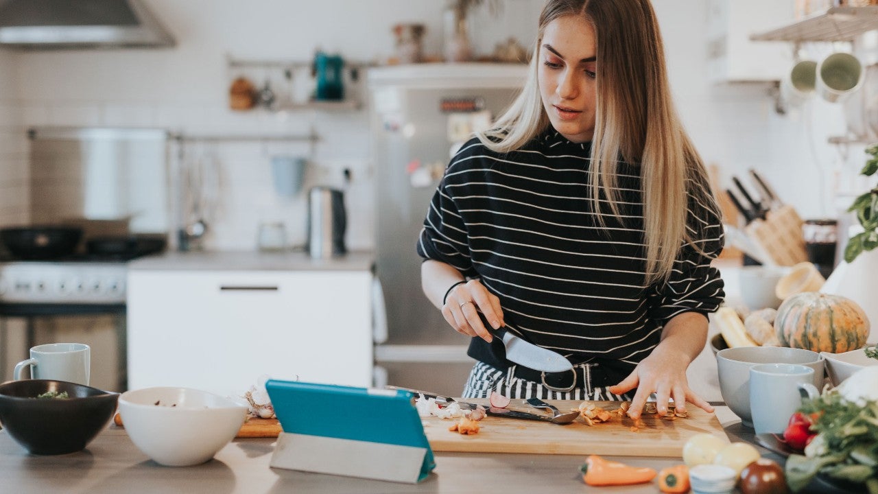 photo-woman-standing-in-kitchen-chopping-vegetables