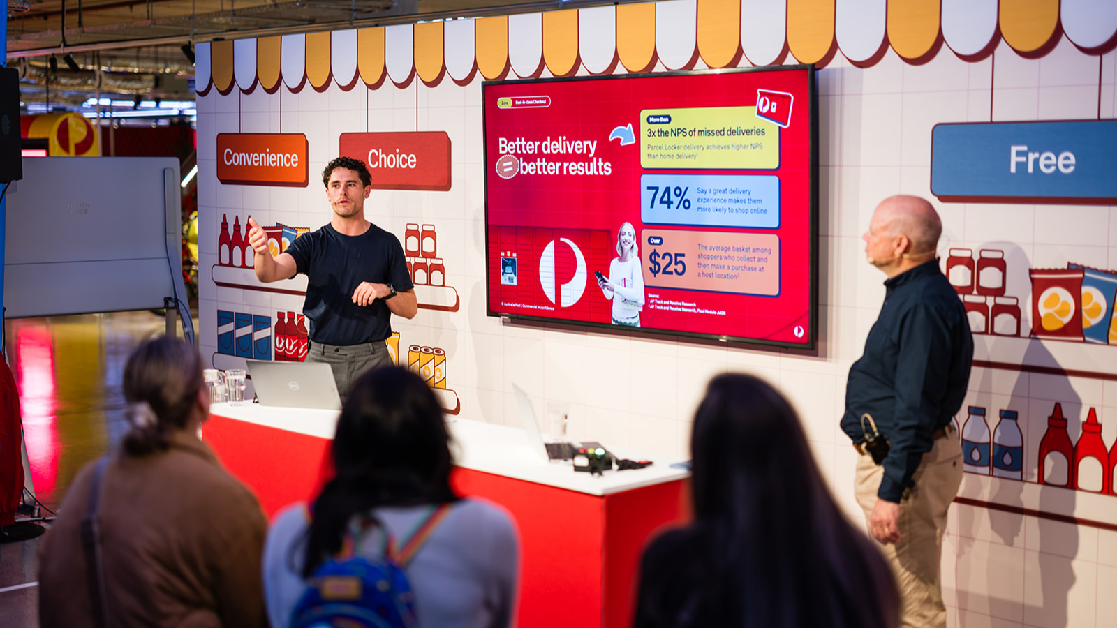 Presenter explaining Parcel Locker customer and commercial benefits to Locker Land attendees.