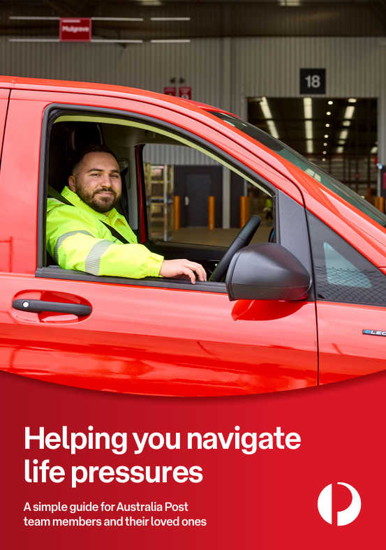 A man in full uniform sitting behind the wheel of a red postal delivery van