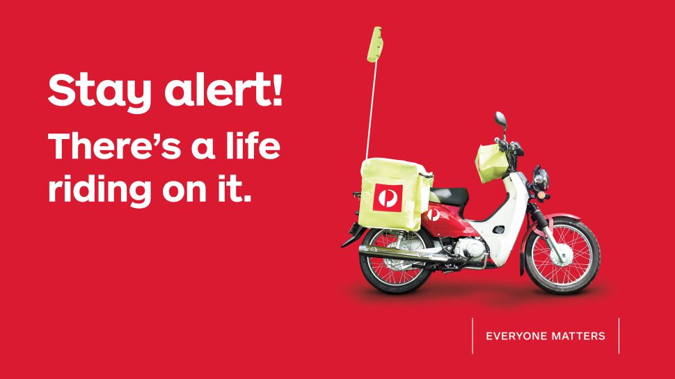 Photo of a postie's motorcycle with the text "Stay safe. There's a life riding on it." and the tag line "Everyone matters"