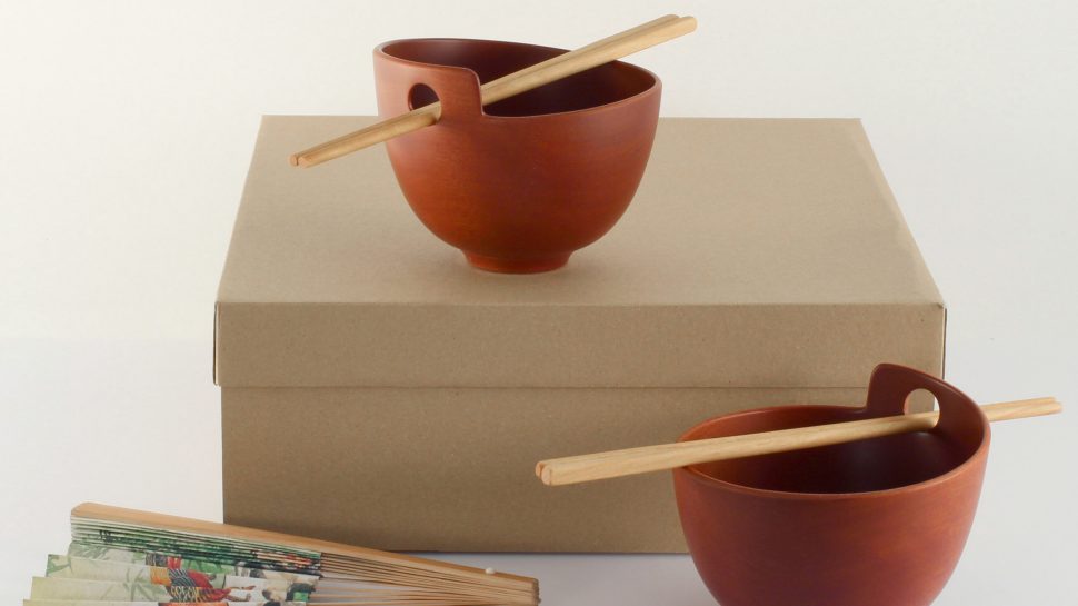Two wooden rice bowls with chopsticks in them