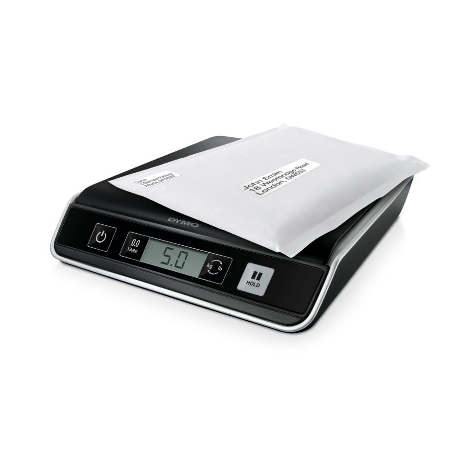Black digital scales with white envelope resting on top.