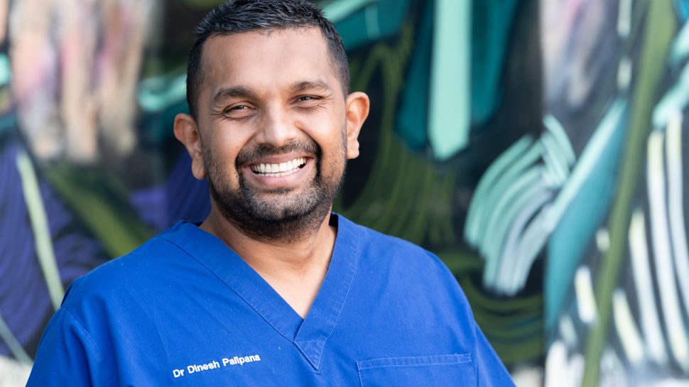 Dr Dinesh Palipana wearing blue scrubs