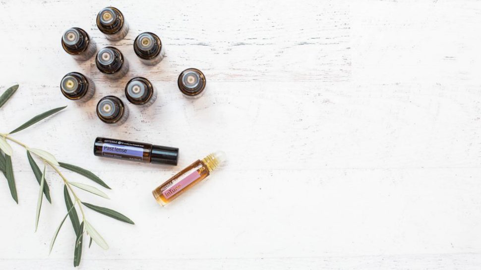 Small bottles of essential oils laid out on a table. 