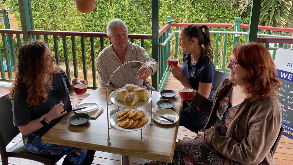 Four people connecting over morning tea.