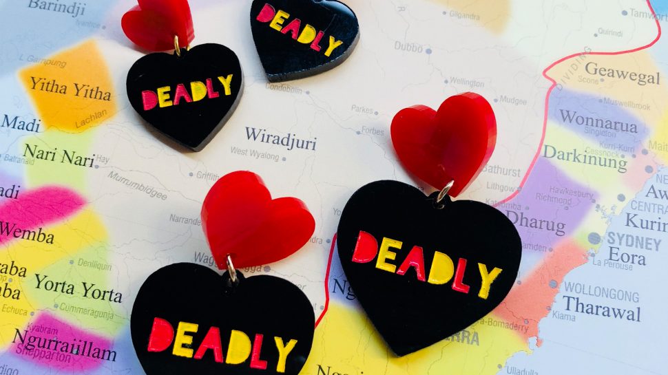 Two pairs of heart shaped earrings with the word ‘Deadly’ painted on them.  