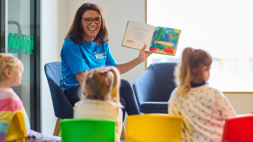 Shelley Ware reading a First Nations book to children in a classroom.