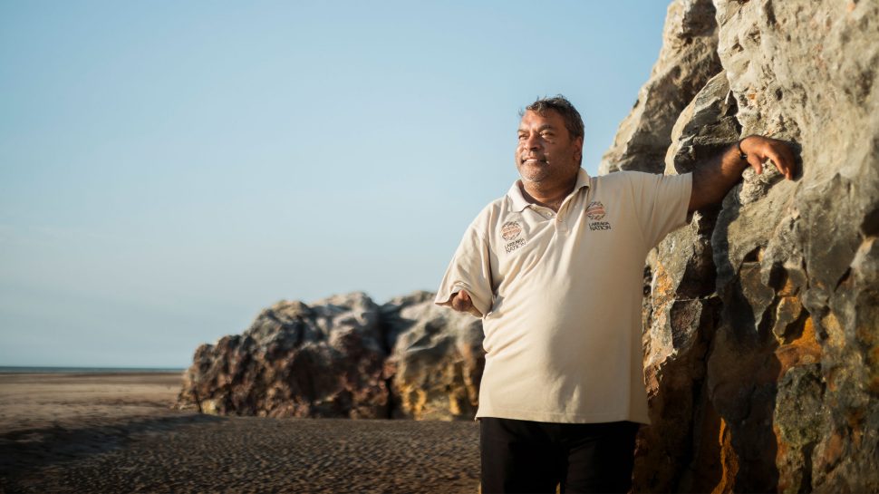 Senior Larrakia Elder, Uncle Doctor Richard Fejo, standing on the beach in Gulmerrogin/Darwin