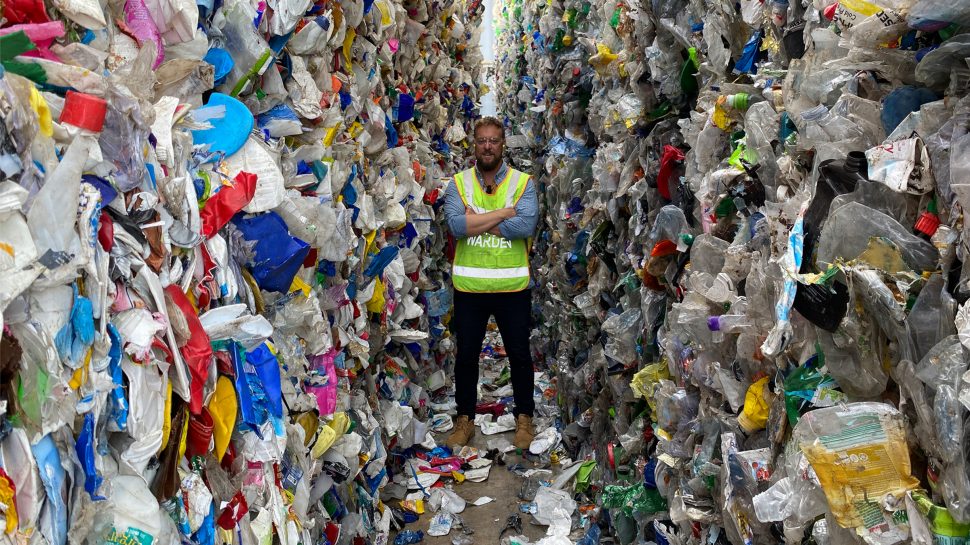 Mike standing surrounded by recyclable plastic rubbish that will be used for Zero Co’s sustainable ‘forever bottles’ 