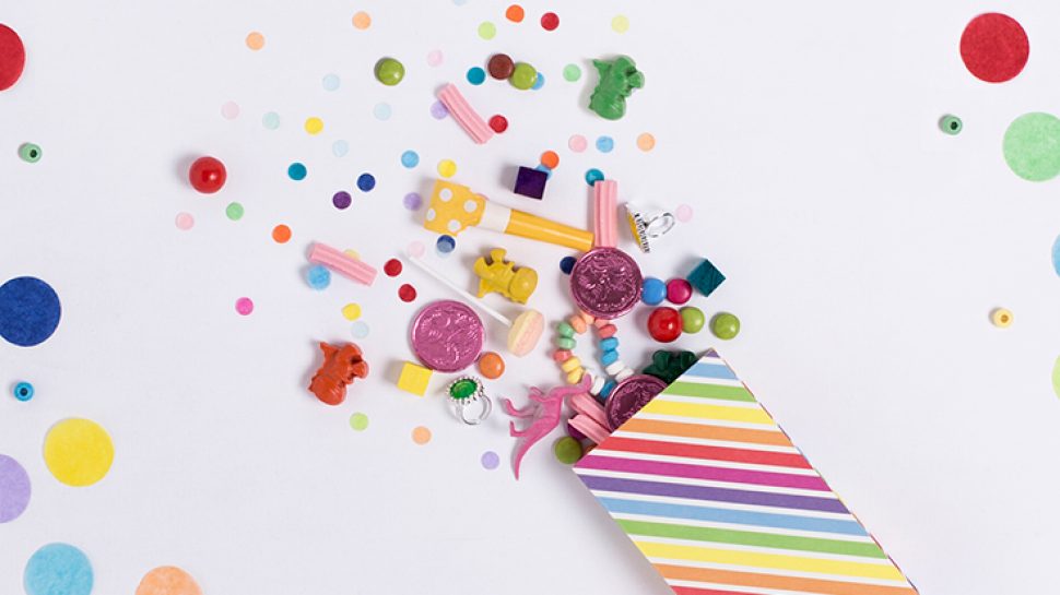1. Colourful party bag, laid flat with lollies tumbling out.