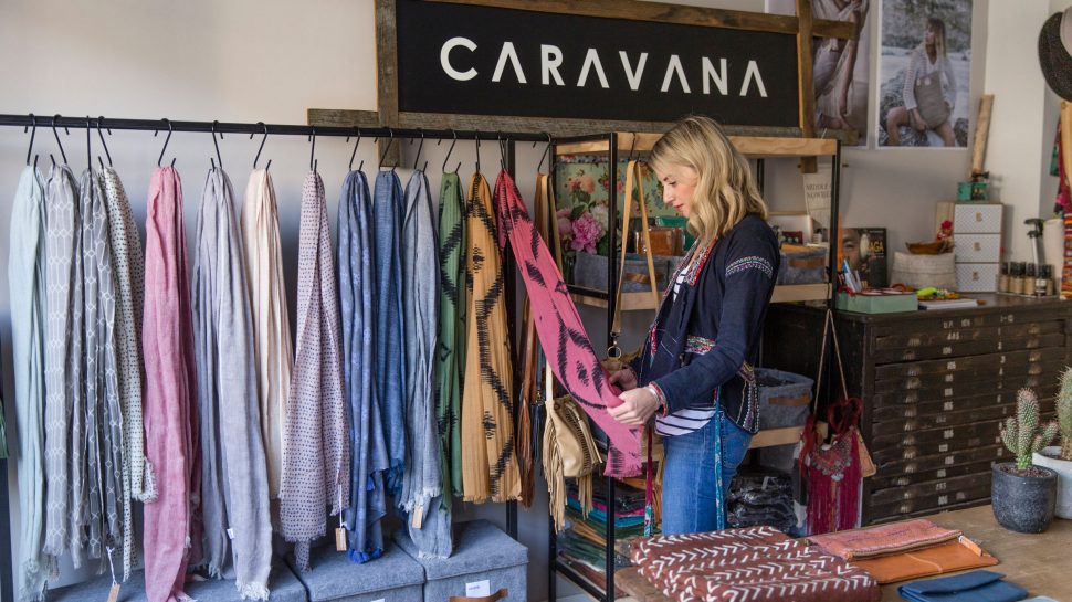 Jackie standing in front of a display of accessories, looking at a beautiful scarf