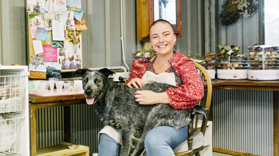 River Hazel relaxes in her studio with her pet Blue Heeler on her lap. 