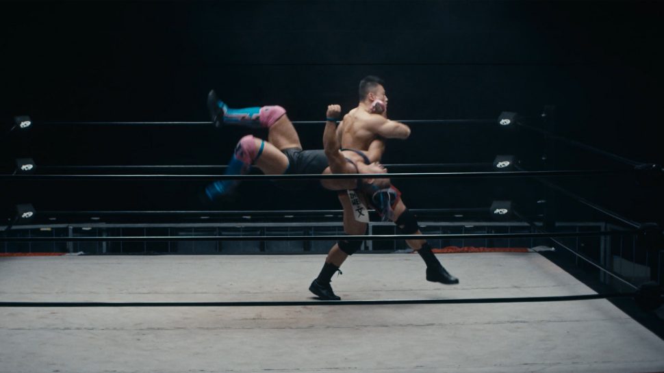 Two wrestlers are grappling in the ring and one is flipping the other over