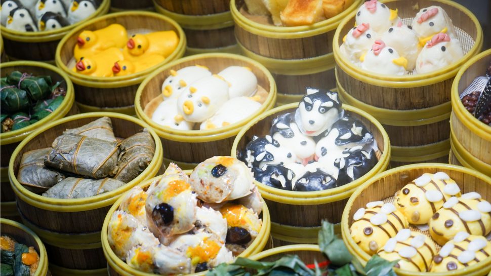 Close-up of multiple bamboo baskets with different dumplings and steamed buns, with some that look like animals.
