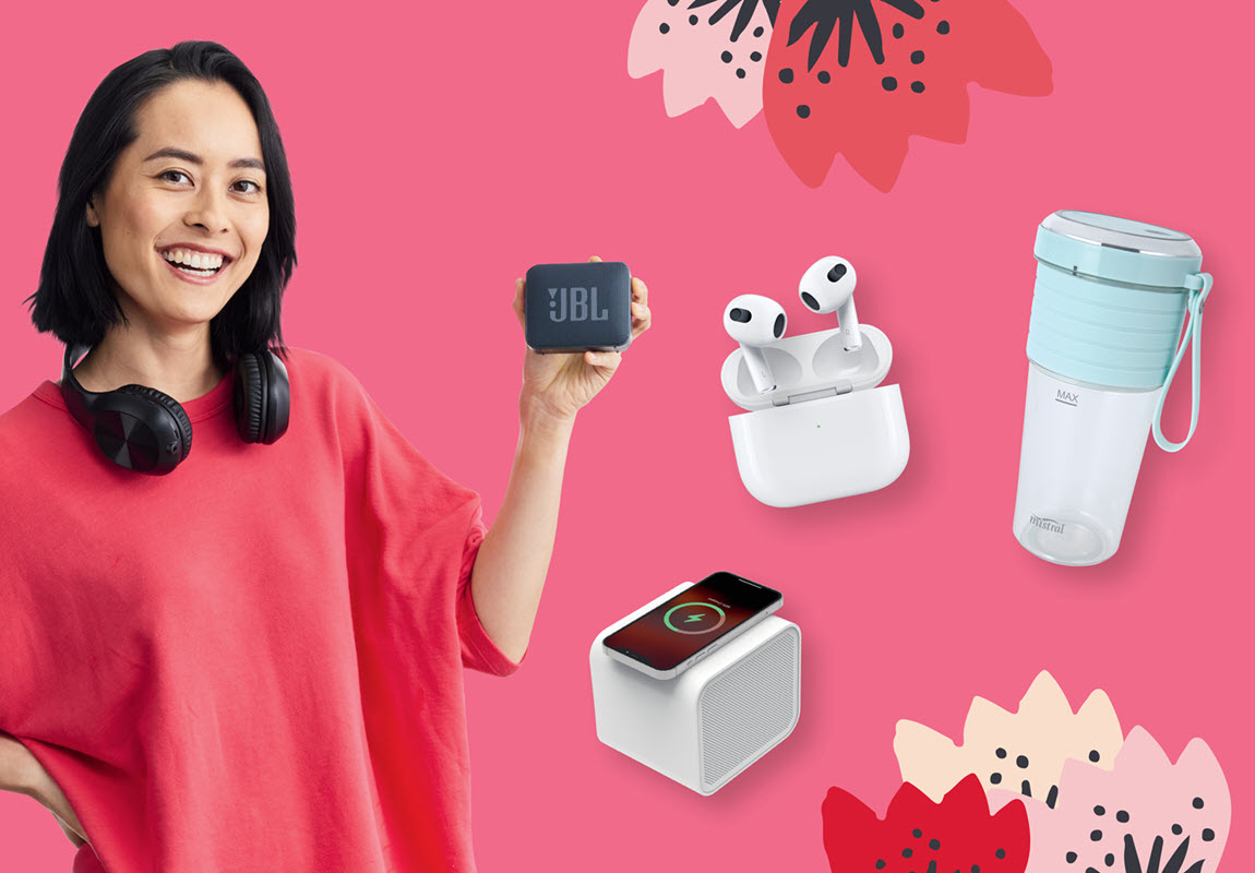 Woman holding JBL earphones and surrounded by other tech products